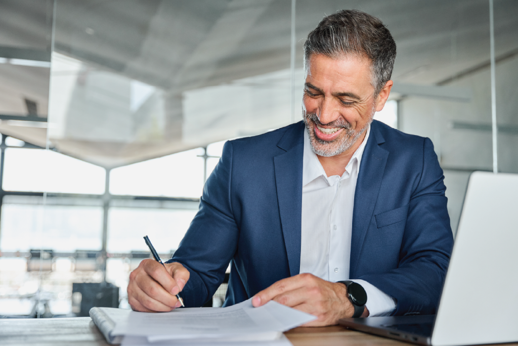 An attorney in a blue suit signing a document